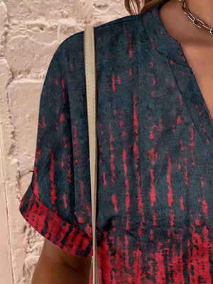 Bohemian tapestry henley blouse with a dark green and red tie-dye pattern.