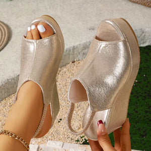 Gold high heel wedge sandals with peep toe and elastic strap detail.