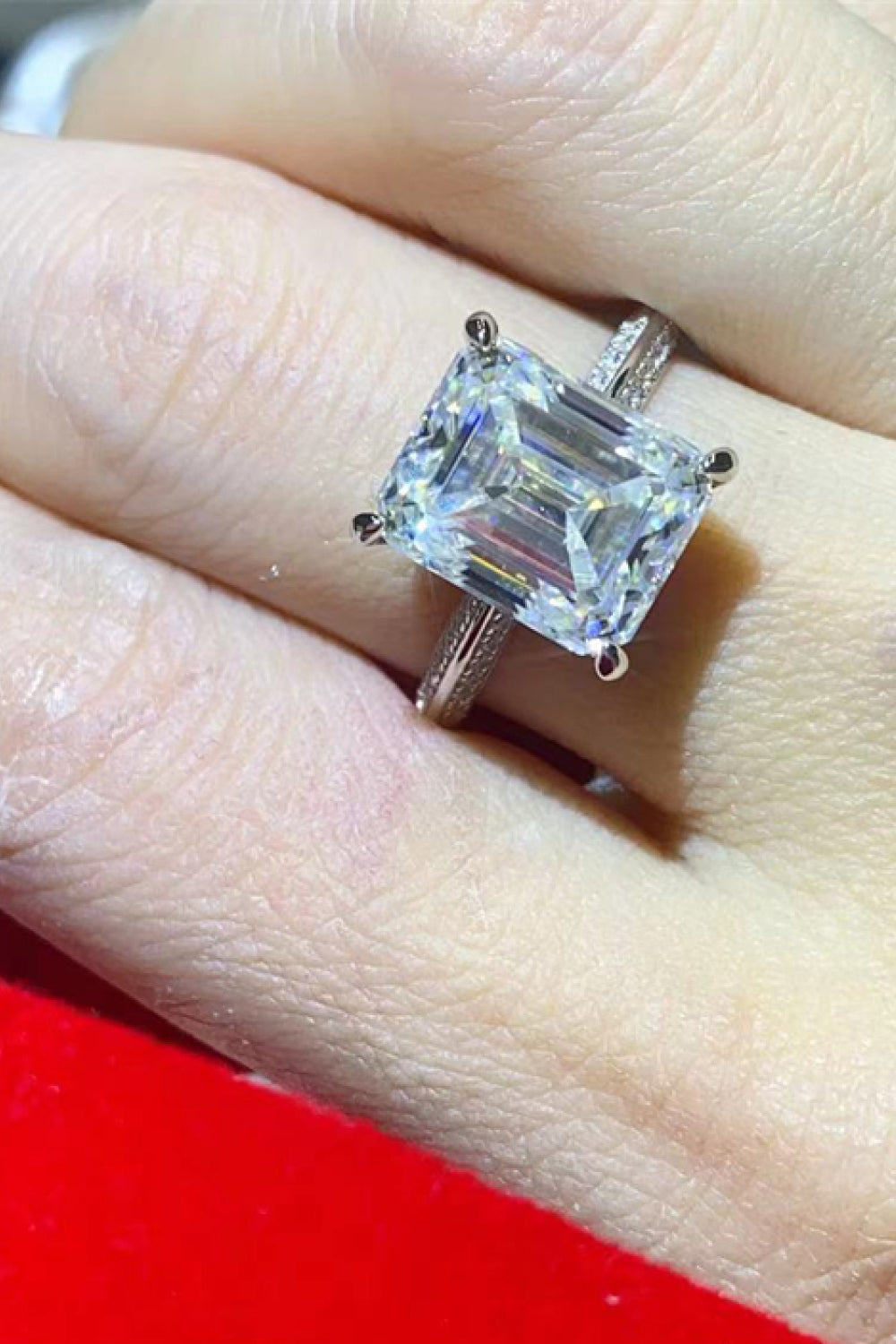Platinum engagement ring with a large emerald cut diamond and textured band.
