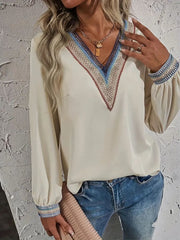 Beige V-neck blouse with embroidered trim on neckline and cuffs, long sleeves