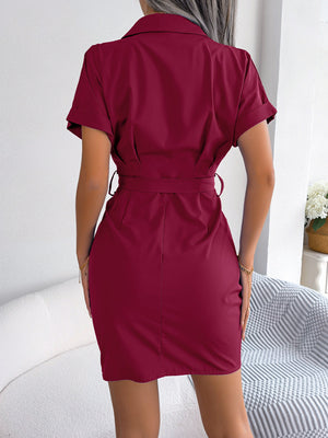 Burgundy belted shirt dress with asymmetric ruche detail and short sleeves.