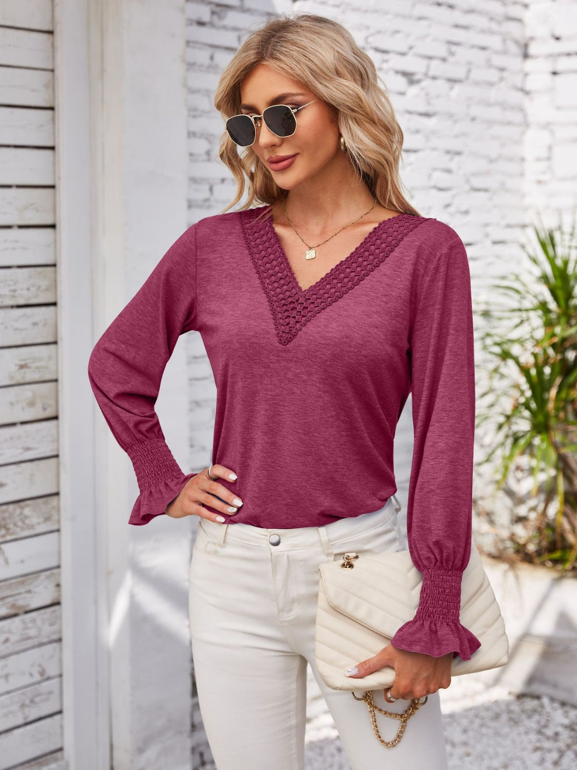 Lace trim V-neck blouse in a deep pink with blouson sleeves and smocked cuffs.