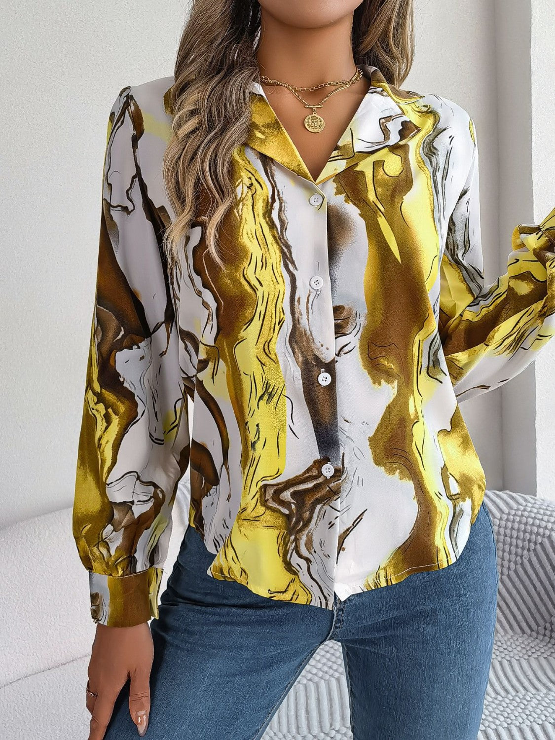Women's abstract swirl print silk blouse in yellow and white with button front and collar.