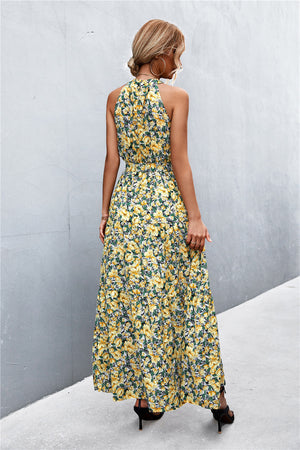 Yellow floral print maxi dress with halter neckline and tiered skirt.
