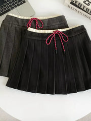 Chic pleated skirt in black and dark gray with drawstring waist and white trim.