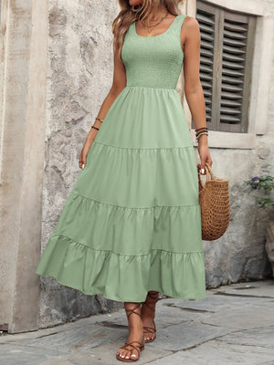 Light green smocked bodice tiered maxi dress with scoop neck and sleeveless design.