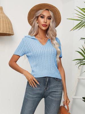 Light blue cable knit polo top with short sleeves and a V-neck collar.