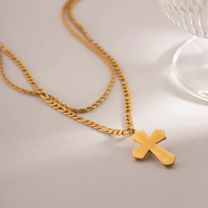 Gold layered chain necklace with a sculpted cross pendant.