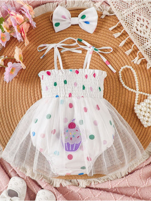 White smocked bodysuit dress with cupcake applique and polka dots, includes matching bow headband.