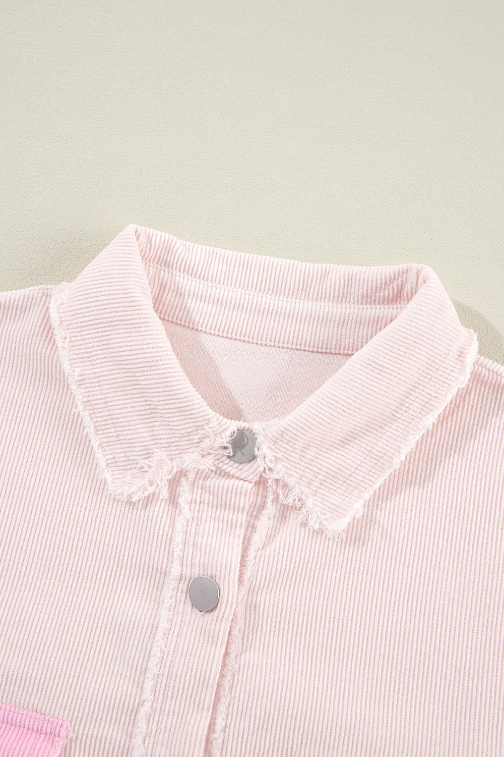 Blush pink corduroy shacket with raw edge collar and button front detail.