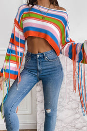 Cropped knit sweater with multicolor stripes and fringe sleeves, off-the-shoulder neckline.