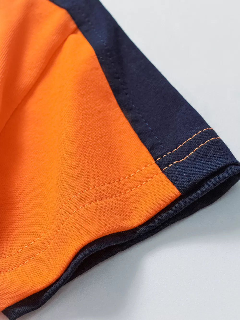 Orange cotton boys' underwear set with navy trim and stitching detail.