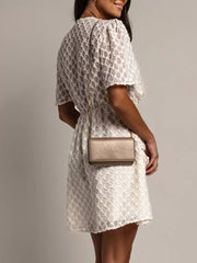 Textured V-neck ruched mini dress in off-white with short sleeves and a subtle geometric pattern.
