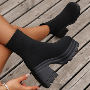 Black knit sock boots with a chunky platform and block heel.