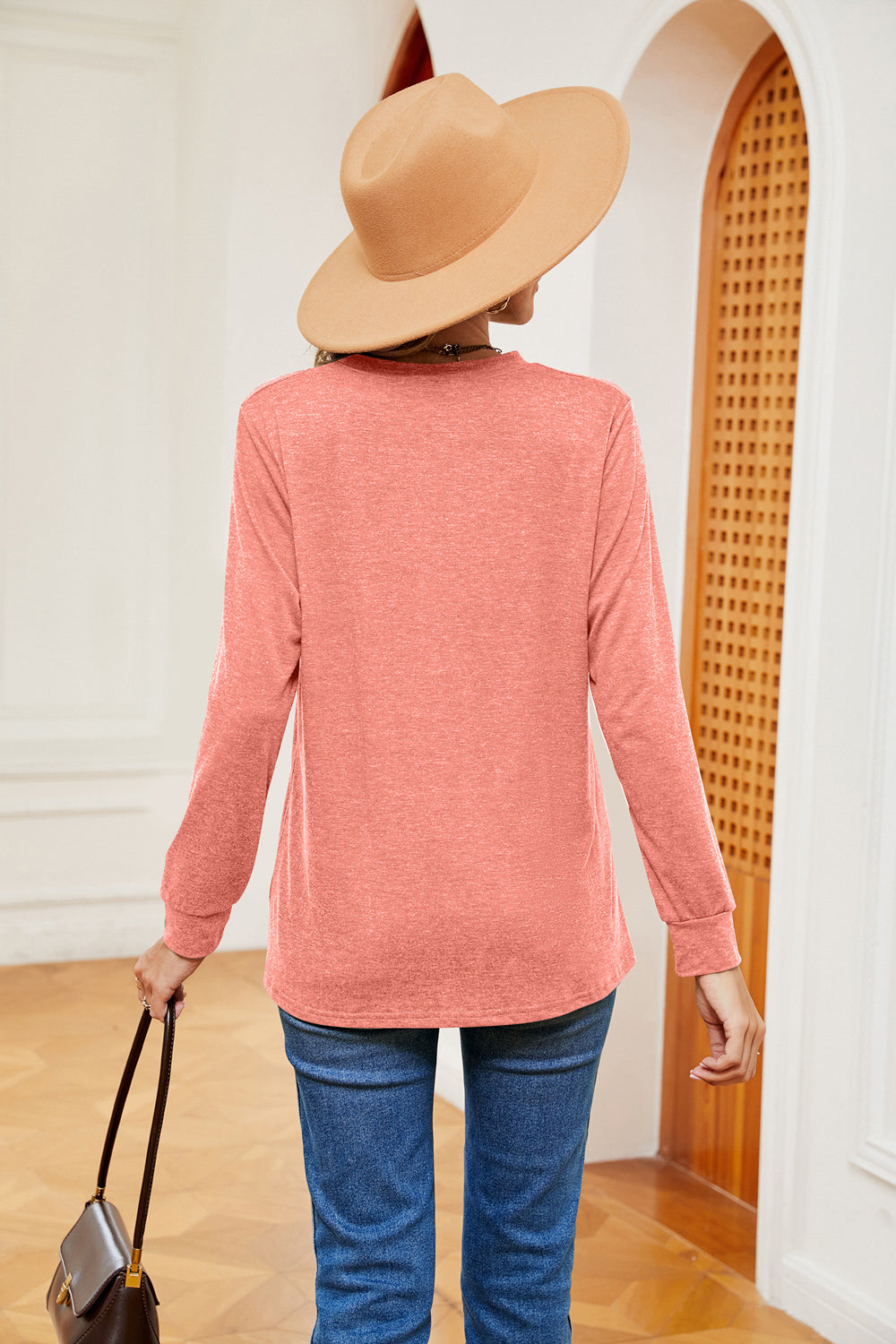 Coral long sleeve henley top with crew neck and cuffed sleeves, worn with jeans.