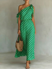 Green polka dot one-shoulder maxi dress with cinched waist and tie details.