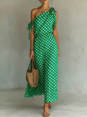 Green polka dot one-shoulder maxi dress with cinched waist and tie details.