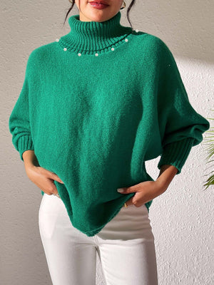 Green knit sweater with dolman sleeves, turtleneck, and pearl embellishments.