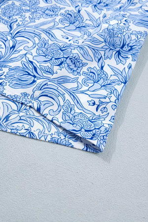 Floral pleated blouse with square neckline in blue and white polyester.