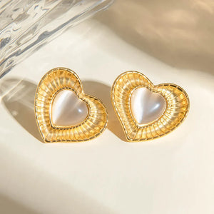 Golden heart cabochon stud earrings with textured gold trim and iridescent center.