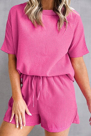 Hot pink waffle knit co-ord set with drawstring shorts and short sleeve top.
