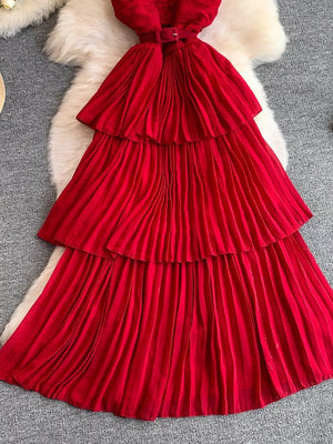 Red belted midi dress with tiered pleated skirt and spaghetti straps.