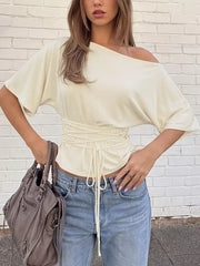 Apricot draped tie-front short sleeve t-shirt with dolman sleeves and asymmetrical neckline.