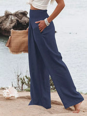Dark blue smocked maternity pants with wide legs and pockets, styled with a white top.