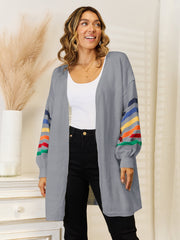Gray knit open-front cardigan with rainbow stripe sleeves and balloon sleeves.