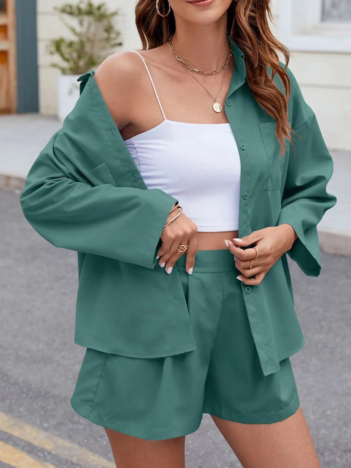Teal pleated shorts and oversized button-down shirt set with a white crop top.