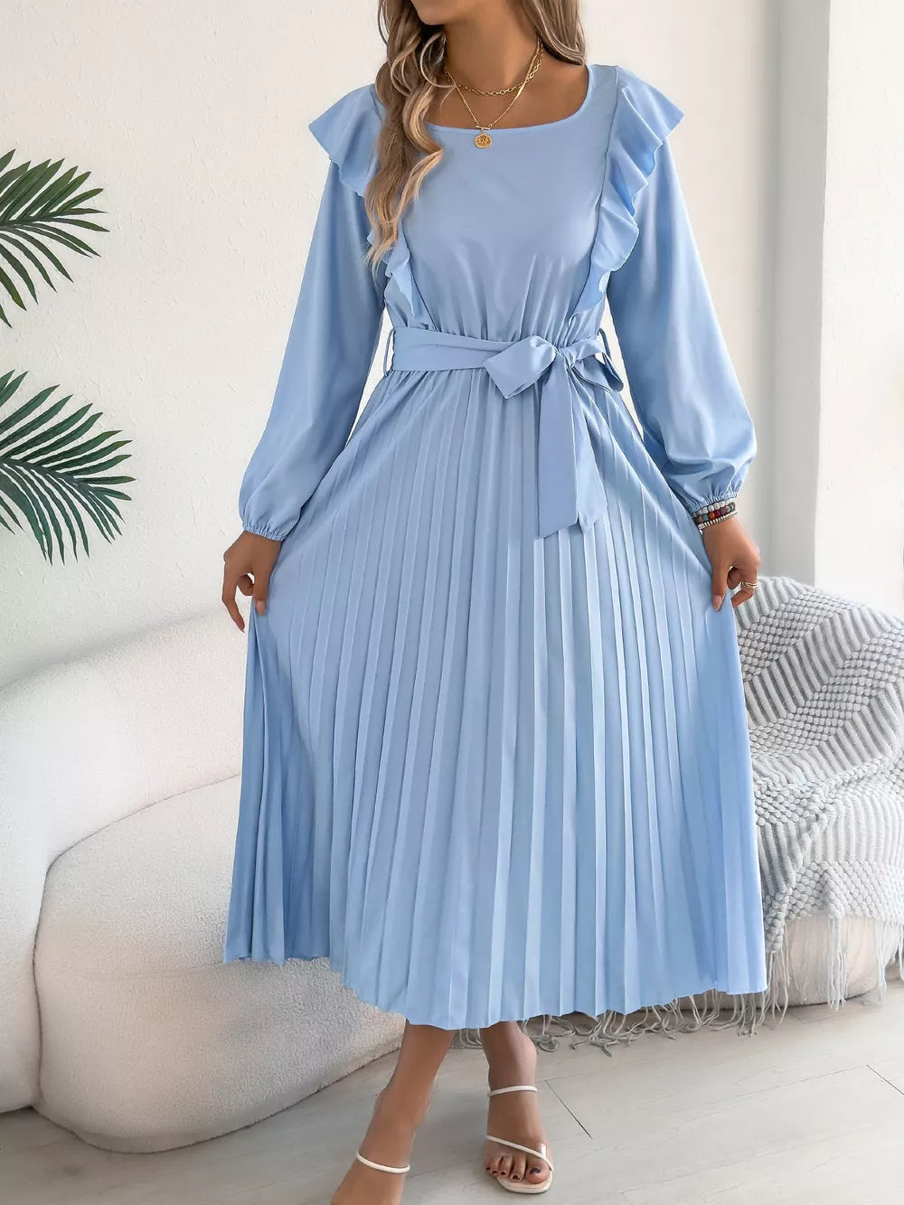 Blue midi dress with ruffles, long sleeves, belted waist, and pleated skirt.