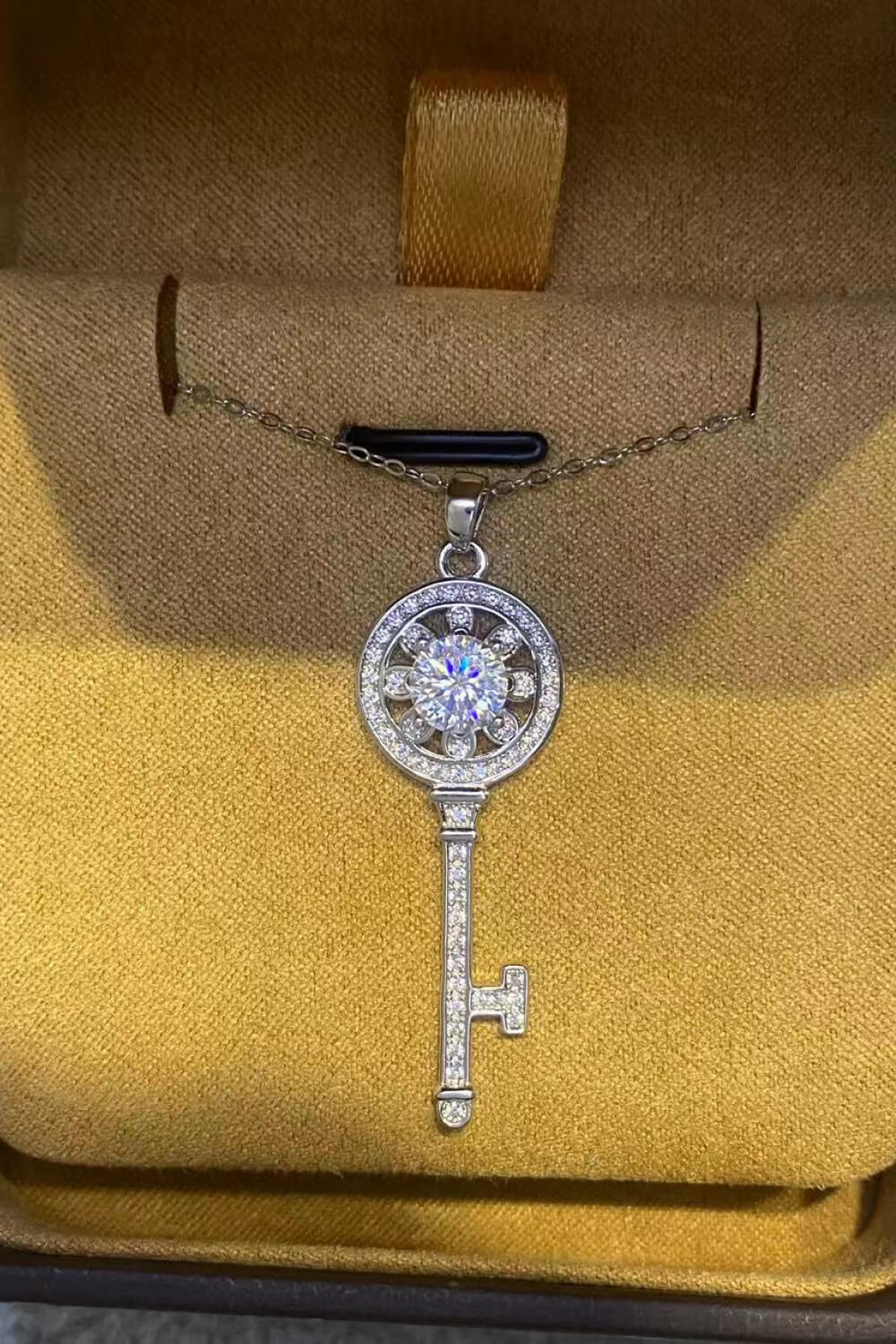 Silver key pendant necklace with floral detail and sparkling stones