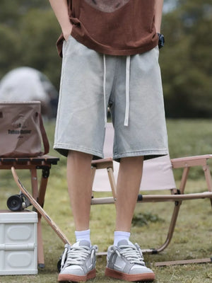 Light blue relaxed fit denim shorts with drawstring waist and pockets.