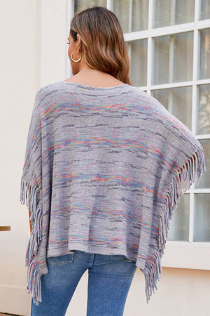Multicolor knit poncho with fringe detail, crew neck, and relaxed fit.