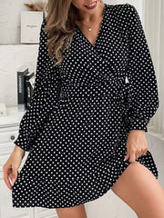 Black polka dot mini dress with V-neck, balloon sleeves, and ruffled hem.