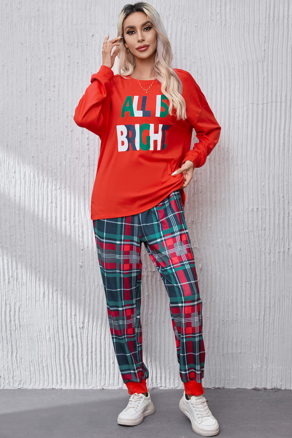 Red long sleeve top with "ALL IS BRIGHT" graphic and plaid lounge pants.