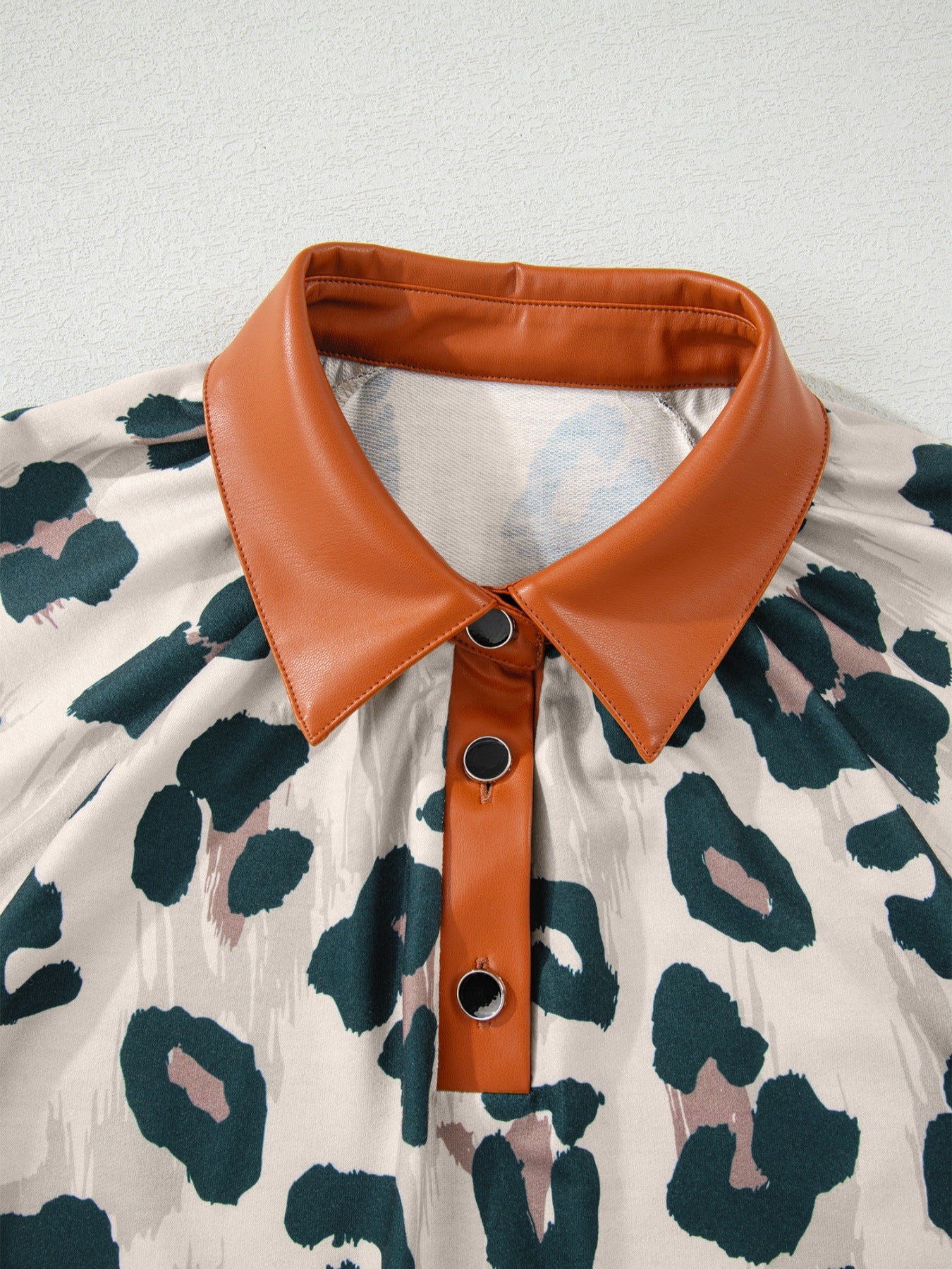 Print short sleeve blouse with faux leather collar and button placket, animal print pattern.