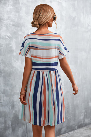 Striped trapeze dress with short sleeves and a gathered waist, featuring horizontal and vertical stripes in coral, navy, and