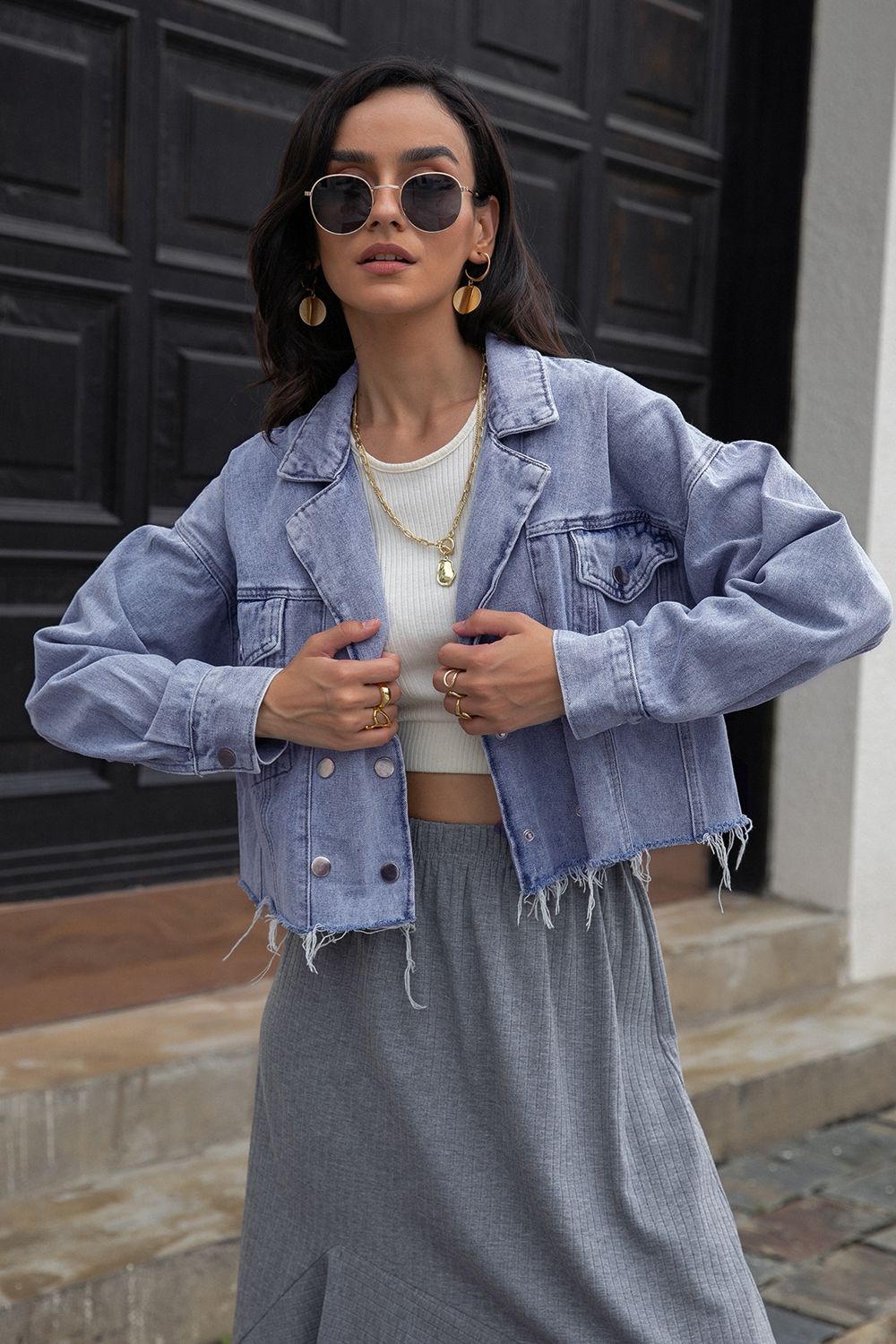 Light wash denim cropped trucker jacket with raw hem and button front.