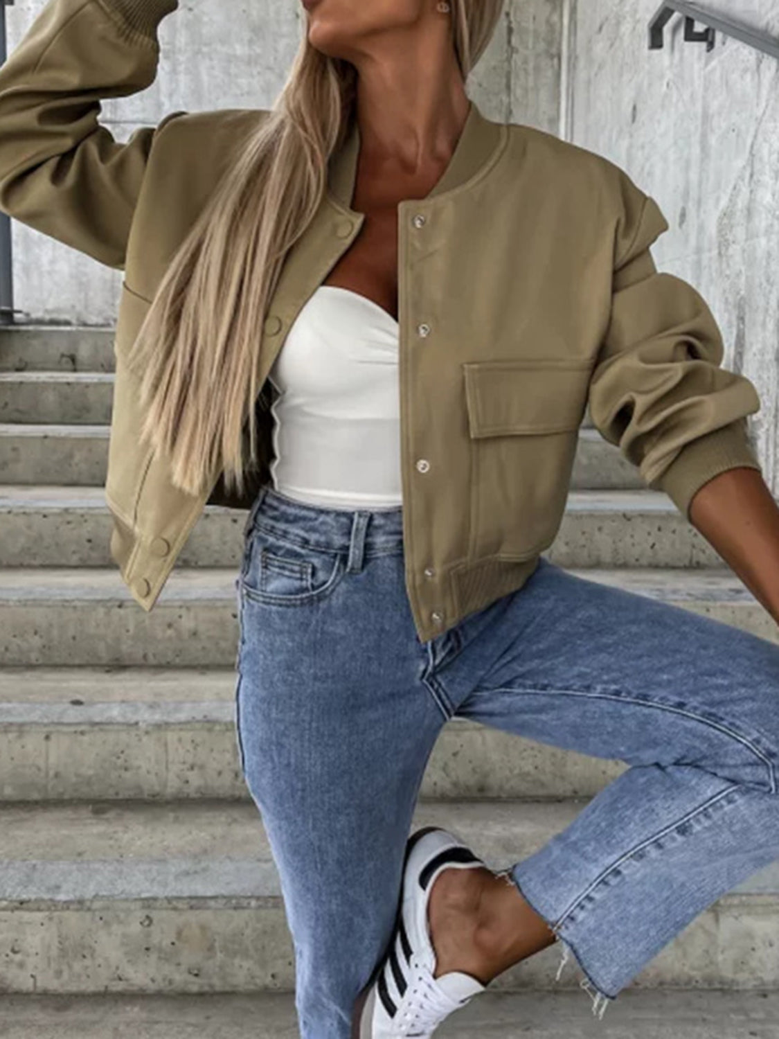 Olive faux leather bomber jacket with sculpted sleeves and pocket details.
