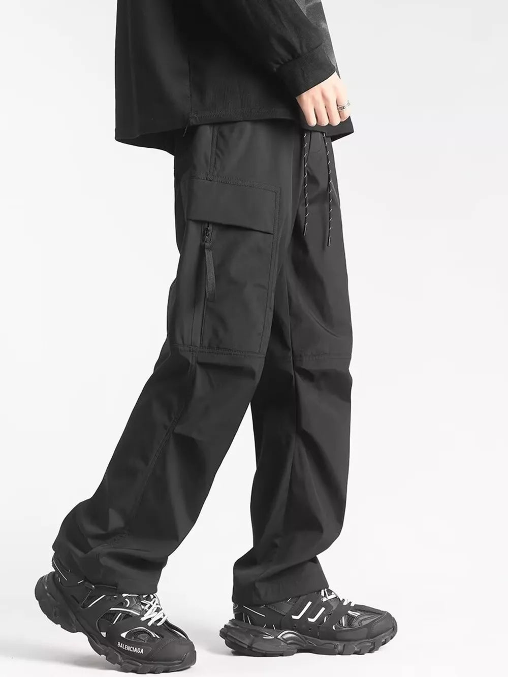 Men's black relaxed fit cargo sweatpants with ankle drawstring and zippered pocket detail.
