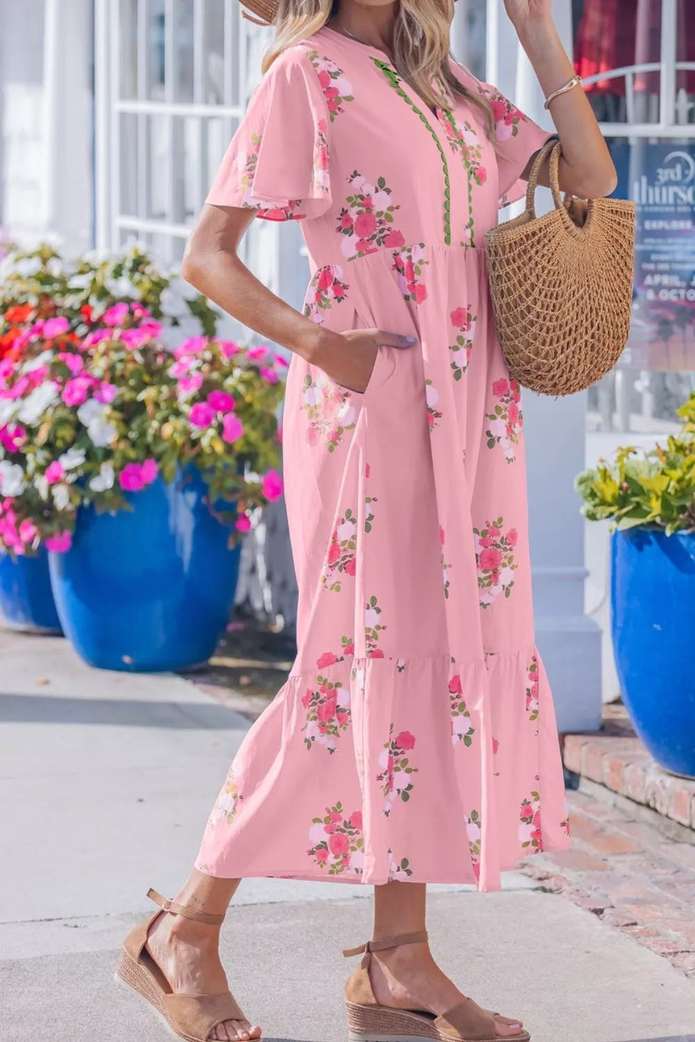 Pink floral cotton midi dress with flutter sleeves and tiered hem.