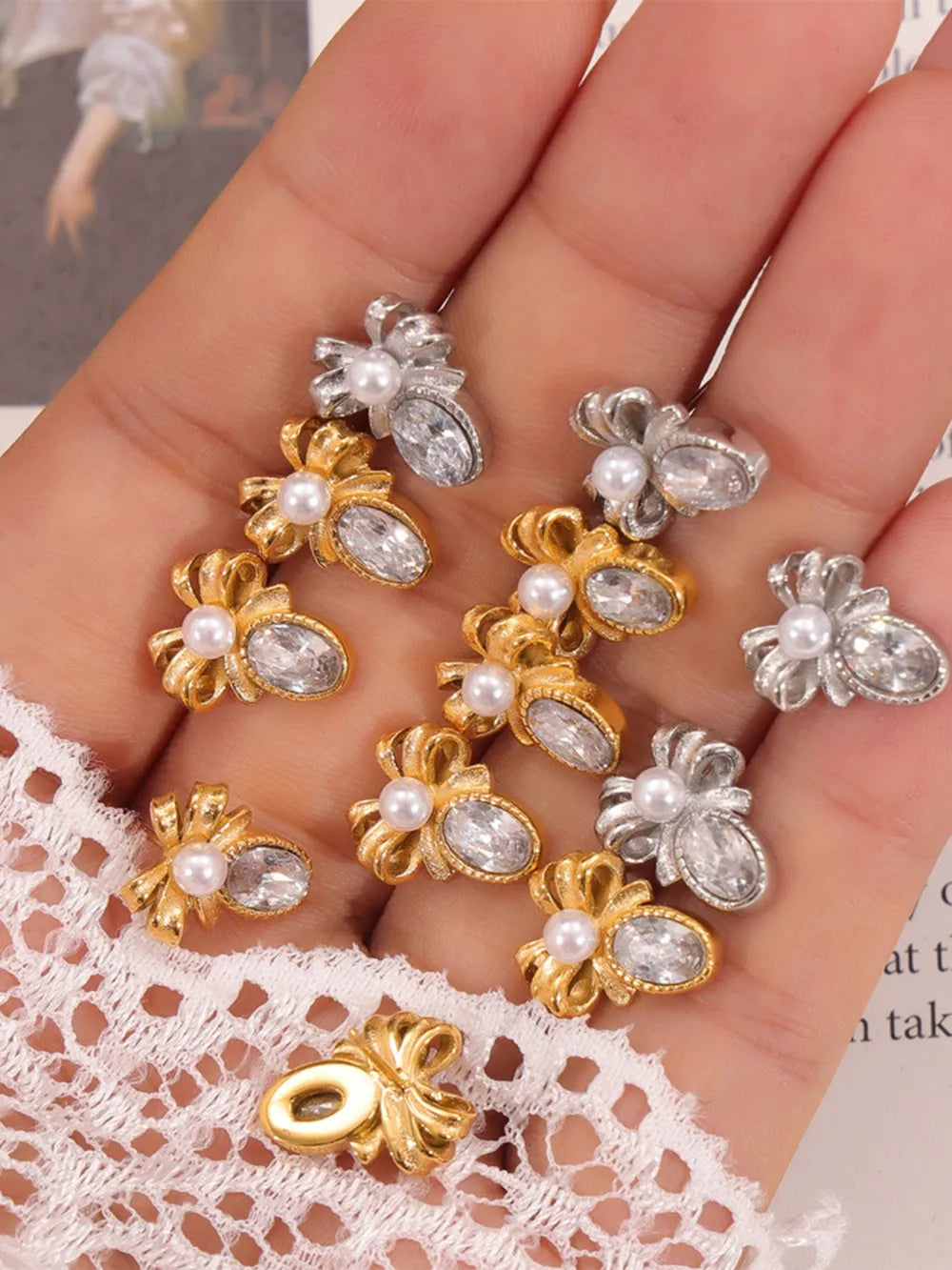 Pearl-crowned bow stud earrings in gold and silver with crystal accents.