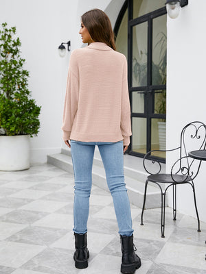 Blush pink textured mock neck knit sweater with long sleeves.