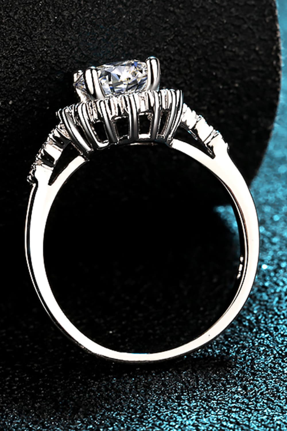Silver halo cluster moissanite engagement ring with a round center stone and pave band.
