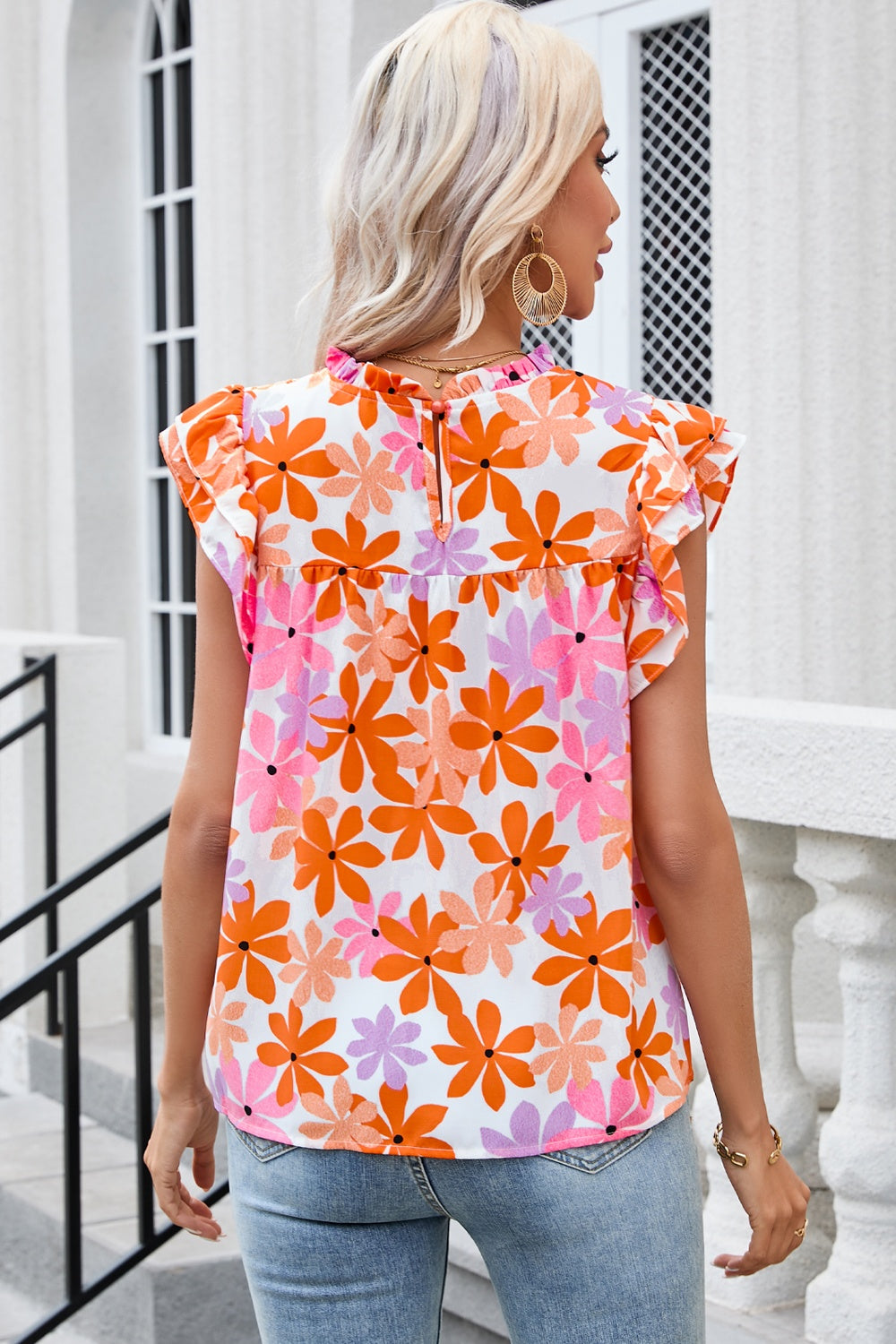 Multicolor floral print blouse with flutter sleeves and ruffled neckline.