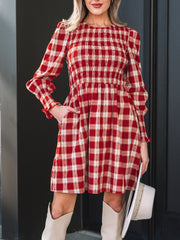 Red plaid cotton mini dress with smocked bodice, puff sleeves, and ruffled cuffs.