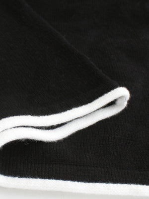 Black maxi dress detail with white ruffled trim neckline
