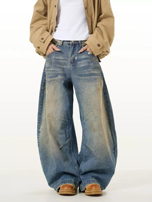 Vintage washed oversized men's jeans in blue denim with distressed details and wide leg.