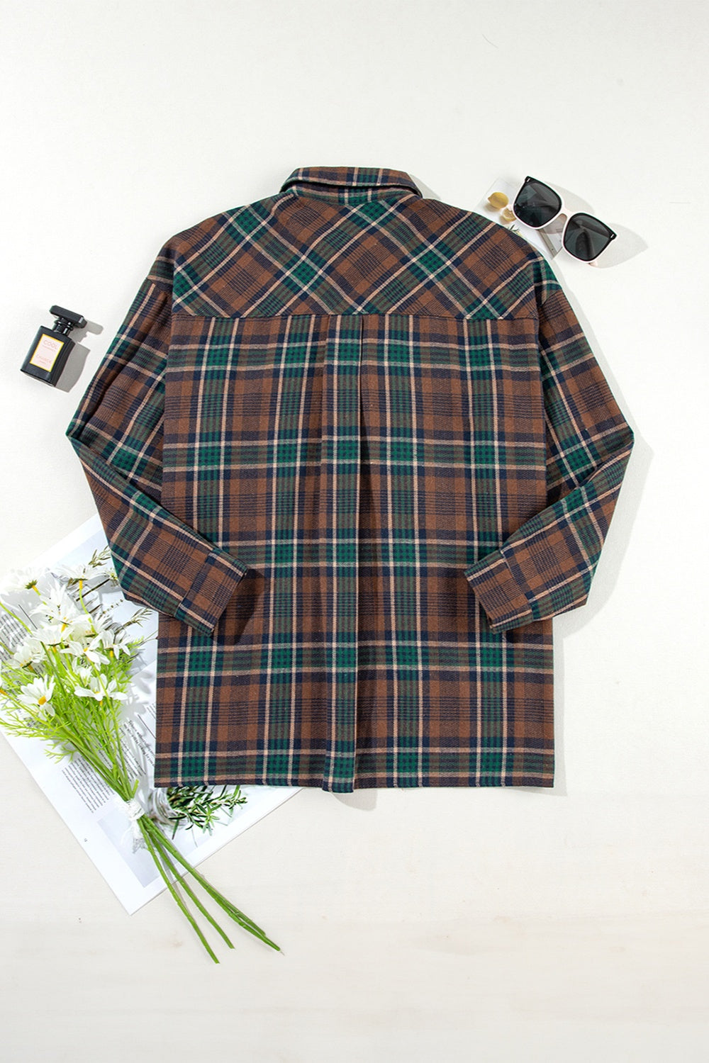 Plaid snap jacket in brown, green, and tan plaid with a collared neckline and long sleeves.